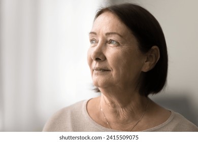 Serious pensive senior woman close up casual portrait with copy space. Thoughtful face of elderly female model looking at window away, daydreaming, thinking, pondering - Powered by Shutterstock