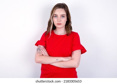 Serious Pensive Young Caucasian Woman Wearing Red T-shirt Over White Background Feel Like Cool Confident Entrepreneur Cross Hands.