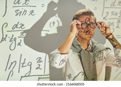 Serious pensive young math analyst with sweater around neck adjusting eyeglasses while preparing for solving equations - Powered by Shutterstock