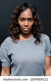 Serious Portrait Of Mature Black Woman With Black Background. Looking To Camera.