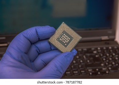 Serious processor security hole. CPU vulnerability. A hand holds a processor in front of a computer screen. Focus on the processor. Concept: cyber security