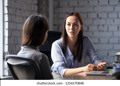Serious professional female advisor consulting client at meeting talking having business conversation or making offer, insurer giving advice, mentor teaching intern, hr speaking at job interview