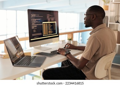 Serious programmer working on computer at office desk