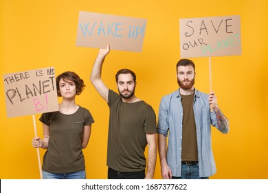 Serious protesting young three people guys girl hold protest signs broadsheet placard isolated on yellow background in studio. Stop nature garbage, ecology environment protection concept. Save planet - Powered by Shutterstock