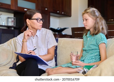 Serious Sad Child Girl And Female Psychologist Teacher At Session