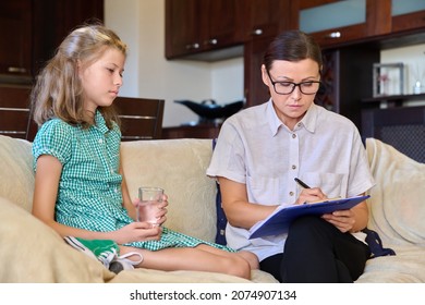 Serious Sad Child Girl And Female Psychologist Teacher At Session