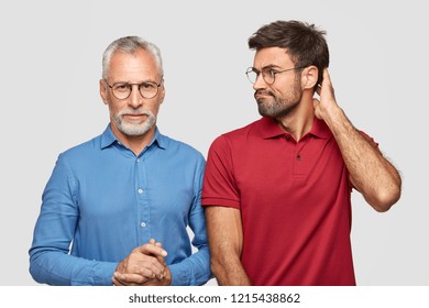 Serious Senior Bearded Man In Blue Elegant Shirt Have Talk With Son Who Looks At Him With Puzzlement, Cant Find Common Solution Or Language, Collaborate Together, Isolated Over White Background