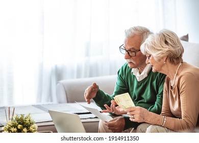 Serious Senior Husband And Wife Doing Their Home Financials In The Living Room. Senior Couple Taking Care Of Bills. Senior Couple Going Over Their Household Finances On A Laptop