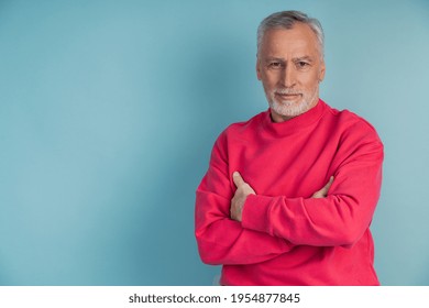 Serious, senior man crossed his arms over his chest posing on a blue background. Attractive man isolated on copy space - Powered by Shutterstock