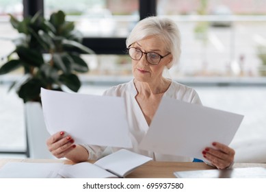 Serious Smart Woman Comparing Two Documents