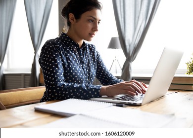 Serious Smart Young Indian Ethnic Woman Student Professional Using Laptop Notebook Educational Software Typing On Computer Studying In Internet Working Online From Home Concept Sit At Office Desk