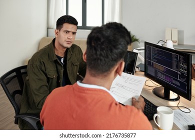 Serious Software Developer Listening To Ideas Of Front End Developer At Meeting