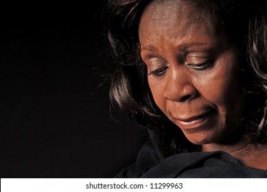 Serious or somber beautiful black woman looking down