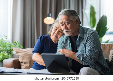 Serious Stressed Asian Senior Old Couple Worried About Bills Discuss Unpaid Bank Debt Paper, Sad Poor Retired Family Looking At Tablet Counting Loan Payment Worry About Money Problem