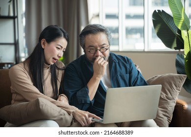 Serious Stressed Middle-aged Asian Couple Finances Calculate Bills Tax On The Laptop.