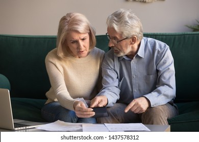 Serious stressed senior old couple worried about paperwork discuss unpaid bank debt calculate bills, shocked poor retired family looking at calculator counting loan payment upset about money problem - Shutterstock ID 1437578312