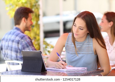 Serious Student Taking Notes E-learning Watching Content In A Tablet In A Bar