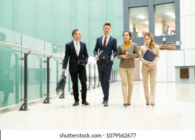 Serious Successful Male Manager Presenting Company To New Employees While Guiding Tour For Them In Modern Office