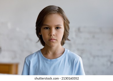 Serious Sulky Handsome Pre-teen 10s Boy Pose Alone In Living Room Staring At Camera Looks Gloomy, Head Shot. Adolescence, Difficult Personality, Bad Temper, Young Generation Z Child Portrait Concept