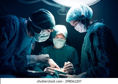 Serious surgeons during a surgery in the hospital. Cross Process - Powered by Shutterstock
