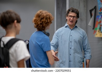 Serious Teacher Communicating With Schoolboys At The Recess