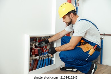 Serious Technician, Plumber In Uniform Checking Water Consumption, Pipes And Meter Counter In Apartment