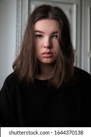 Serious Teenager Girl In A Black Sweater In The Room Portrait