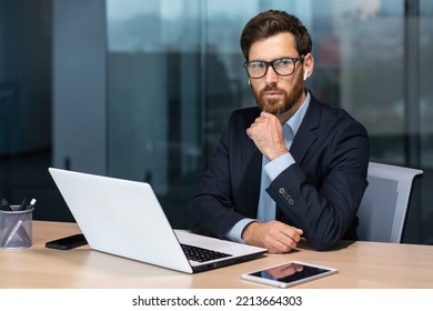 Serious Thinking Mature Businessman Working Inside Modern Office Building, Senior Boss In Business Suit And Glasses Working Sitting At Laptop, Man With Beard Thinking About Future Strategy Plan