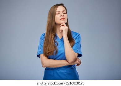 Serious Thinking Nurse Woman In Blue Medical Uniform Standing With Eyes Closed. Isolated Female Portrait.