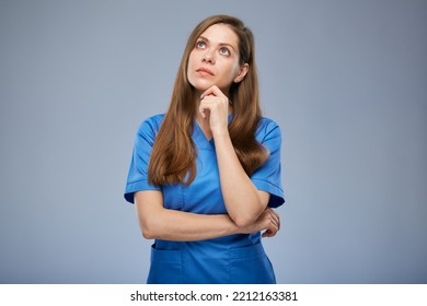 Serious Thinking Nurse Woman In Blue Medical Uniform Looking Up. Isolated Female Portrait.