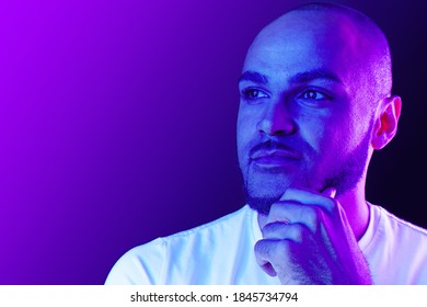 Serious thoughtful black guy portrait in neon light
