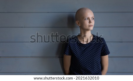 Serious thoughtful cancer fighter looking away with hope. Ill young woman with shaved head fighting against oncology illness, thinking of chemotherapy, remission with confidence. Head shot portrait