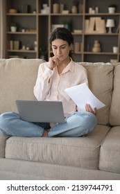 Serious Thoughtful Freelancer Woman Doing Business Paperwork At Home, Working Laptop Computer On Couch. Renter Girl Paying Domestic Bills, Taxes, Using Online App For Online Payment. Vertical Shot