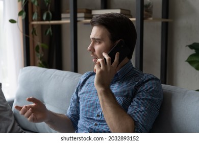 Serious Thoughtful Mobile Phone User Making Telephone Call From Home, Speaking On Cell. Businessman, Self Employed Specialist, Remote Worker Sitting On Couch, Discussing Work On Cellphone