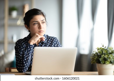 Serious Thoughtful Pensive Young Indian Ethnic Woman Student Sit At Home Office Desk With Laptop Thinking Of Inspiration Solution Lost In Thoughts Dreaming Looking Away Search Creative Ideas Concept