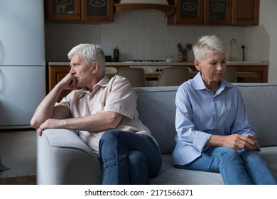 Serious Thoughtful Unhappy Older 60s Wife And Husband Sit On Couch Separately. Couple Experiencing Marriage Crisis, Lack Of Understanding And Patience, Break Up And Hard Decision About Divorce Concept