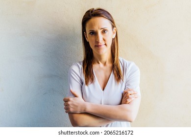 Serious And Tired Middle Aged Beautiful Young Woman With Crossed Arms.