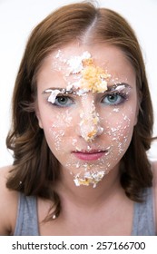 Serious Woman Sitting At The Table With Cake At Her Face