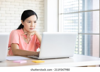 serious woman working laptop computer and thinking about work
