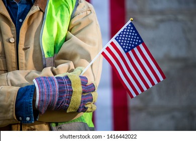 A serious worker man and american flag - Powered by Shutterstock