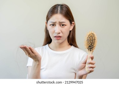 Serious, Worried Asian Young Woman, Girl Holding Brush, Show Her Comb With Long Loss Hair Problem After Brushing, Hair Fall Out Problem. Healthcare, Healthy, Beauty With Copy Space On White Background