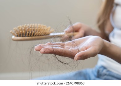 Serious, Worried Asian Young Woman, Girl Holding Comb, Show Her Hairbrush With Long Loss Hair Problem After Brushing, Hair Fall Out Problem. Health Care, Beauty With Copy Space On White Background.