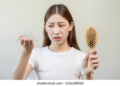 Serious, Worried Asian Young Woman, Girl Holding Comb, Show Her Hairbrush With Long Loss Hair Problem After Brushing, Hair Fall Out Problem. Health Care, Beauty With Copy Space On White Background.