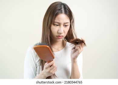 Serious, Worried Asian Young Woman, Girl Holding Brush, Show Her Comb, Hairbrush With Long Loss Hair Problem After Brushing, Hair Fall Out On Her Hand In Living Room. Health Care, Beauty Treatment.