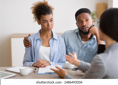 Serious Young Afro Couple Listening To Their Investment Counselor During Financial Consultation In Office. Selective Focus