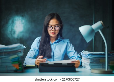 Serious Young Asian Female Business Overtime Work At Desk In Office At Night.