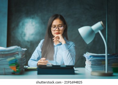 Serious Young Asian Female Business Overtime Work At Desk In Office At Night.