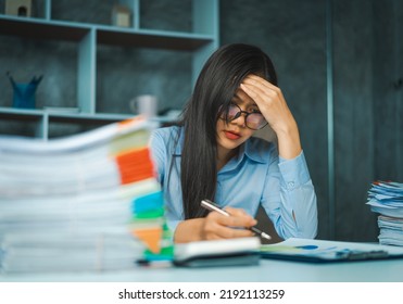 Serious Young Asian Female Business Overtime Work At Desk In Office At Night.