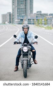 Serious Young Asian Man In Helmet Riding Motorcycle On Highway