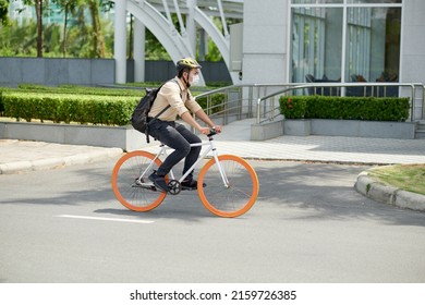 Serious Young Asian Man In Medical Mask Riding To Work Or University In Morning